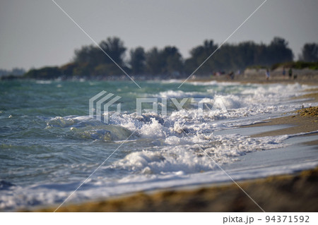 Seaside sand beach with foamy waves crushing on shore 94371592