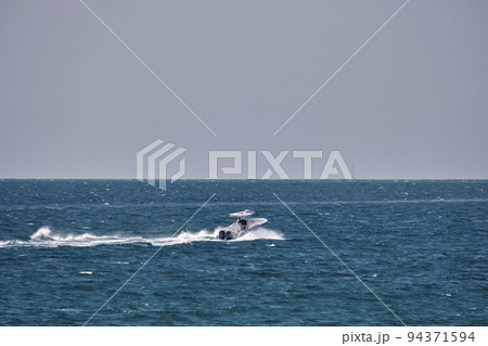 Seascape with ripple surface of blue sea water with white speedboat swimming fast on calm waves 94371594