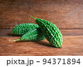 Wild bitter gourd on a wooden background. 94371894