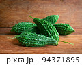 Wild bitter gourd on a wooden background. 94371895