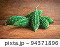 Wild bitter gourd on a wooden background. 94371896