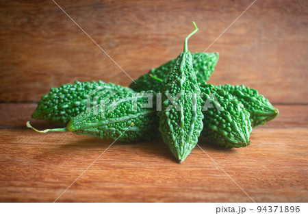 Wild bitter gourd on a wooden background. 94371896
