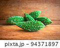 Wild bitter gourd on a wooden background. 94371897