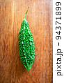 Wild bitter gourd on a wooden background. 94371899