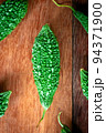 Wild bitter gourd on a wooden background. 94371900