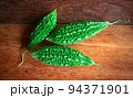 Wild bitter gourd on a wooden background. 94371901