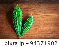 Wild bitter gourd on a wooden background. 94371902
