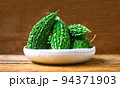 Wild bitter gourd on a wooden background. 94371903