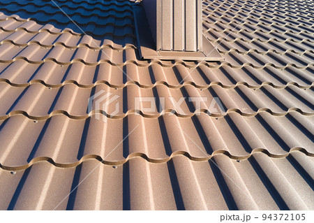 Closeup of house roof top covered with metallic shingles Closeup of house roof top covered with metallic shingles 94372105