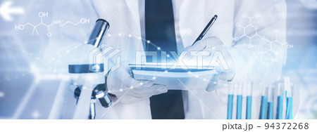 biochemical research scientist working with a microscope for the virus,Doctor man write a history of the experimental results in a , laboratory glassware containing chemical liquid for design. 94372268