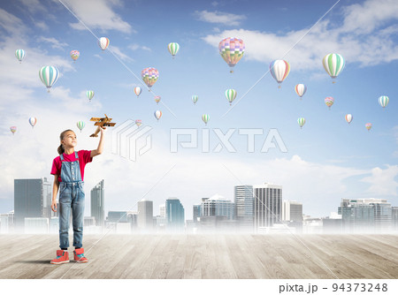 Concept of careless happy childhood with girl dreaming about something 94373248