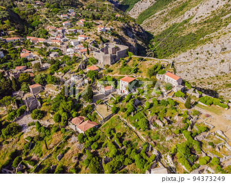 Old city. Sunny view of ruins of citadel in Stari Bar town near Bar city, Montenegro. Drone view Portrait of a disgruntled girl sitting at a cafe table 94373249