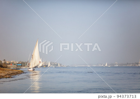 Luxor, Egypt - January 17, 2019: Beautiful fishing and pleasure boats on the Nile in Luxor. Beautiful river and reflections of boats in the water. Clear, sunny day. 94373713