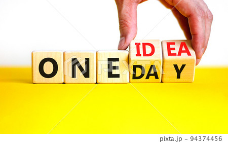 One day and idea symbol. Concept words One day and One idea on wooden cubes. Businessman hand. Beautiful yellow table white background. Business One day and idea concept. Copy space. 94374456