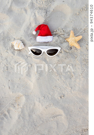 Christmas background Santa Claus hat on the beach with starfish and sunglases Christmas background Santa Claus hat on the beach with starfish and sunglases 94374610