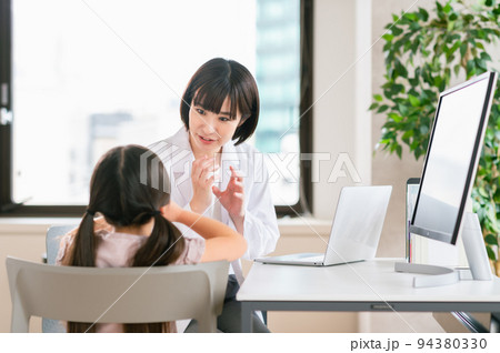 女の子を診察する女性の小児科医 94380330