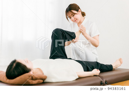患者の足をマッサージする整体師の女性（理学療法士・作業療法士） 94383161