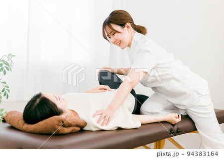 患者をマッサージする整体師の女性 94383164
