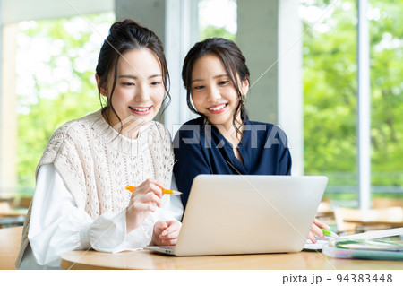 学校でパソコンを見る大学生の女の子 学校でパソコンを見る大学生の女の子 94383448