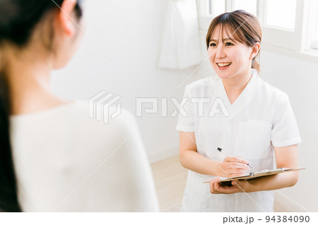 カウンセリングする白衣の女性（看護師・カウンセラー・エステティシャン） 94384090