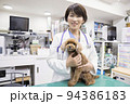 動物病院で犬を抱く女性獣医師 94386183
