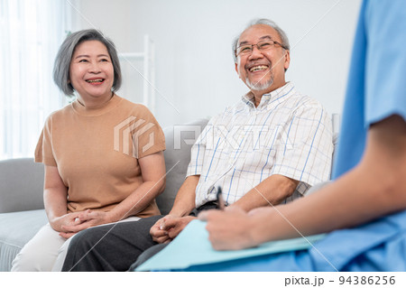 Female doctor visiting and talking to her contented senior couple at their home Female doctor visiting and talking to her contented senior couple at their home 94386256