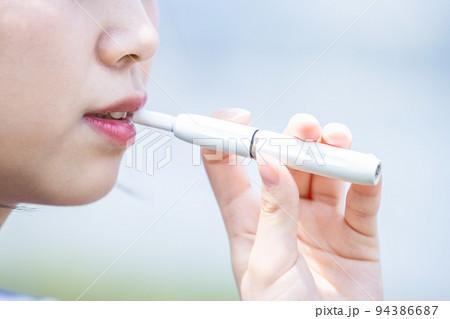 電子タバコを楽しむ若い女性 94386687
