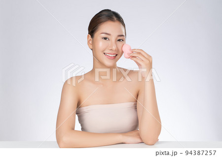 Gorgeous woman applying her cheek with dry powder. Gorgeous woman applying her cheek with dry powder. 94387257
