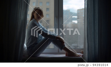 Young woman sitting on the window 94391014