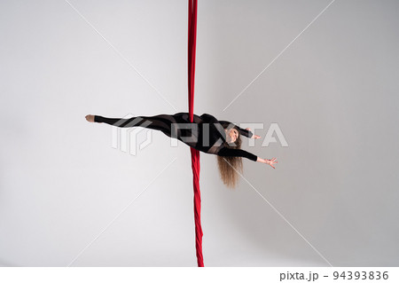 Flexible circus Artist performs on the aerial silk on white background. Concept of willpower, motivation and passion Flexible circus Artist performs on the aerial silk on white background. Concept of willpower, motivation and passion 94393836