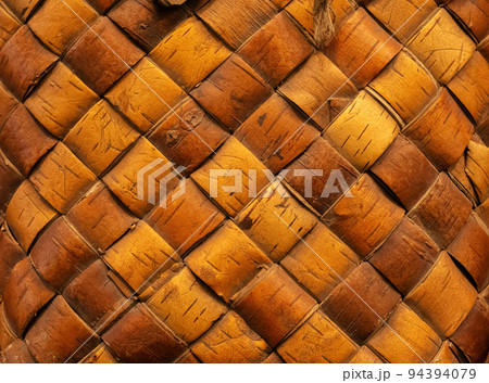 Wicker background from birch bark strips. Natural material. Texture of inner layers of birch bark of different colors with pattern of dark stripe 94394079