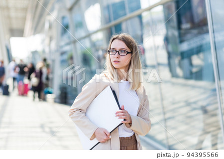 Woman with laptop near modern office center 94395566