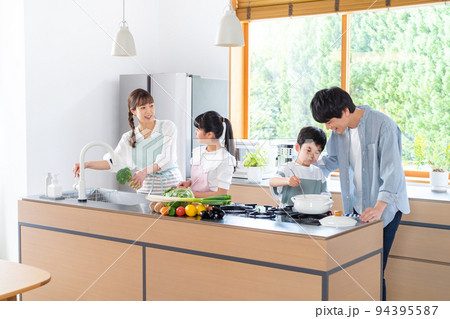 キッチンで料理する4人家族 94395587