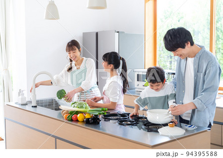 キッチンで料理する4人家族 94395588
