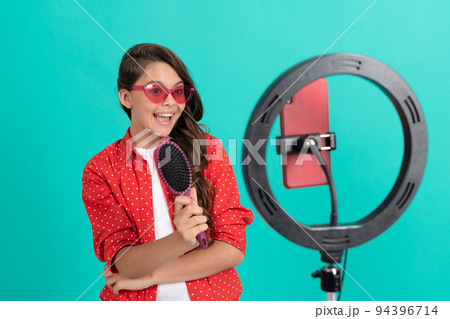 happy kid presenting hairbrush in sunglasses blogging online, advertisement. happy kid presenting hairbrush in sunglasses blogging online, advertisement. 94396714