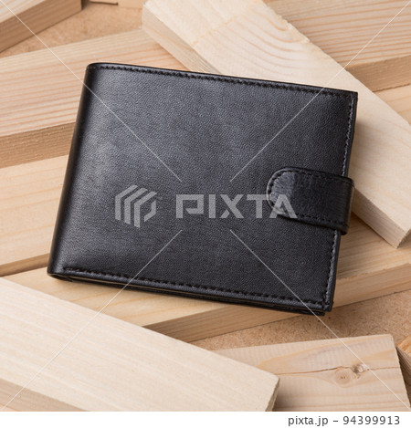 One black leather wallet on a textured wooden background from the boards One black leather wallet on a textured wooden background from the boards 94399913