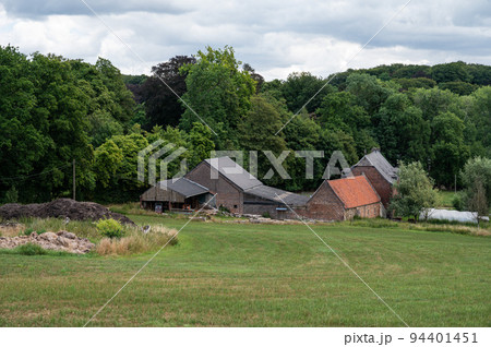 Nethen, Wallon region, Belgium ,  Farm houses and agriculture fields with woods in the background 94401451