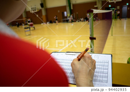 バドミントンの試合会場の体育館アリーナで審判台に座っている女性 94402935