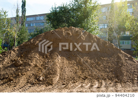 A large mountain of sand in the center of the city brought to repair the road 94404210