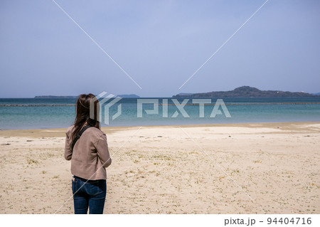 海辺に立って海を眺めている若い女性の後ろ姿 海辺に立って海を眺めている若い女性の後ろ姿 94404716