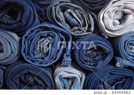 Blue jeans denim heap background. Jeans fabric heap as material surface Blue jeans denim heap background. Jeans fabric heap as material surface 94404962