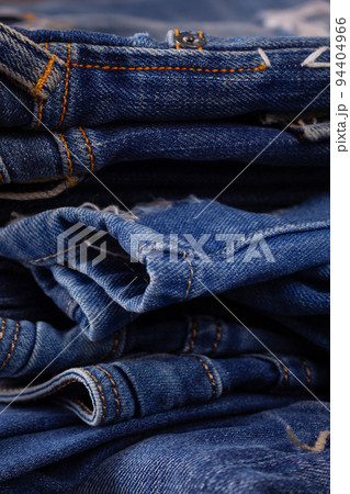 Blue jeans denim heap background. Jeans fabric stack as material surface Blue jeans denim heap background. Jeans fabric stack as material surface 94404966