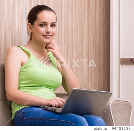 Young woman working at laptop at home Young woman working at laptop at home 94405152