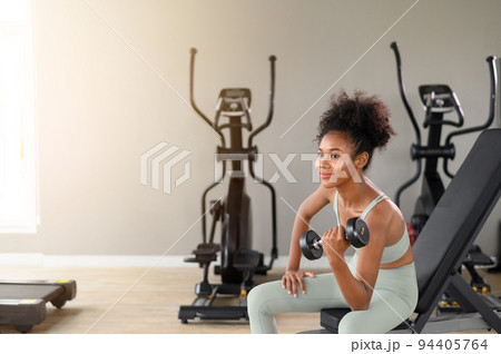 Sporty fitness African American woman working out with dumbbells strength and strength endurance at the gym. Sporty fitness African American woman working out with dumbbells strength and strength endurance at the gym. 94405764