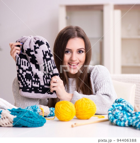 Young beautiful woman knitting at home Young beautiful woman knitting at home 94406388