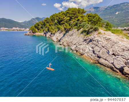 Young women Having Fun Stand Up Paddling in blue water sea in Montenegro. SUP. girl Training on Paddle Board near the rocks Portrait of a disgruntled girl sitting at a cafe table 94407037