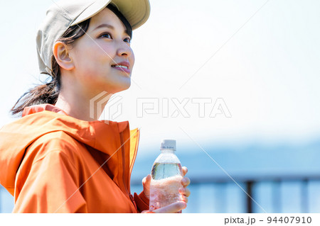 水分補給用のペットボトルを持つ若い女性 水分補給用のペットボトルを持つ若い女性 94407910
