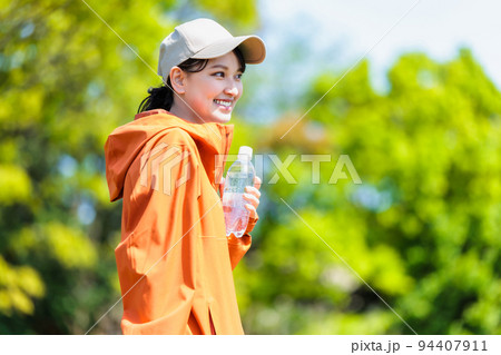 水分補給用のペットボトルを持つ若い女性 水分補給用のペットボトルを持つ若い女性 94407911