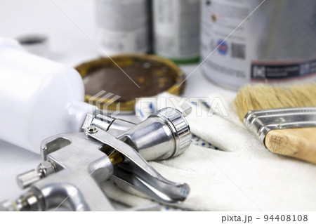 Instructions and a paint spray gun at work at the workplace in the workshop. 94408108