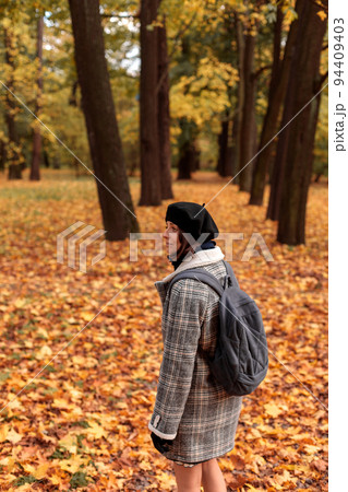 woman walks through an autumn forest or park...の写真素材 [94409403] - PIXTA